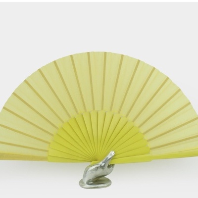 Leque amarelo em suporte de mão metálica