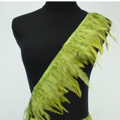 Faixa verde com penas numa diagonal sobre manequim preto