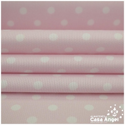 tecido rosa claro com bolinhas brancas empilhado