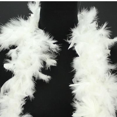 Cachecol ou acessórios de penas brancas contrastando com fundo preto.