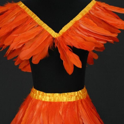 Conjunto de fantasia com penas laranja e fitas amarelas em manequim preto