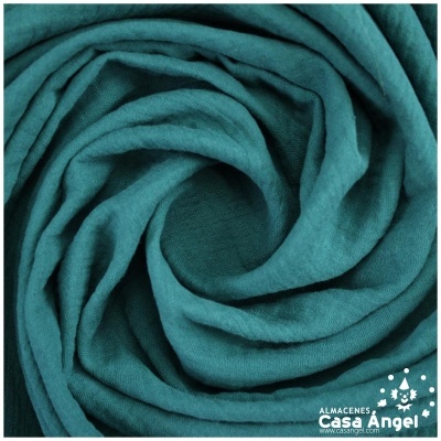 Tecido azul turquesa enrolado em espiral com textura enrugada