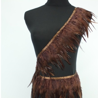 Acessório de penas castanhas sobre tecido preto num manequim