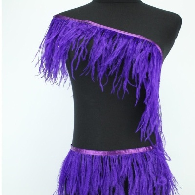 Roupa preta com penas roxas, faixa roxa, em manequim