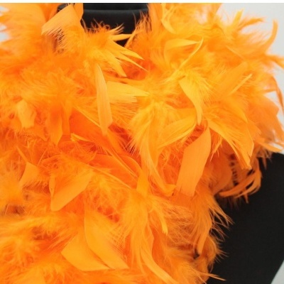 Adereço com penas laranjas vibrantes sobre fundo preto