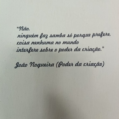 Texto em português sobre fundo branco com citação de João Nogueira