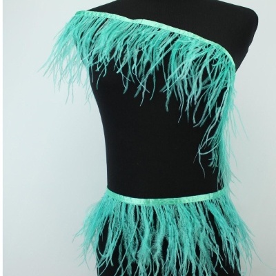 Fita decorativa com franjas em penas verde água em manequim preto