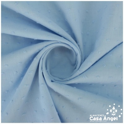 Tecido azul claro com pequenos pontos em relevo dobrado em espiral