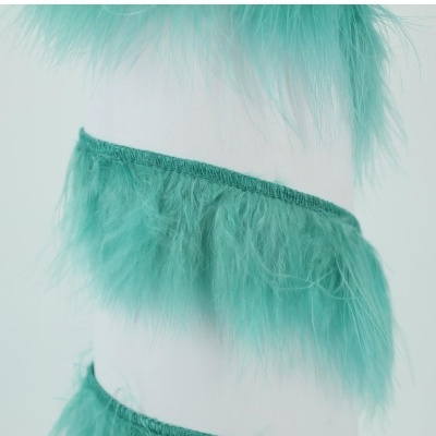 Fita decorativa de penas verdes num carretel branco