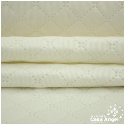 Tecido branco matelassado com padrão de losangos em três camadas dobradas