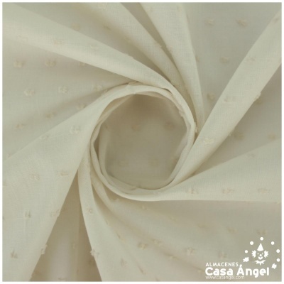 Tecido branco com pequenos pompons enrolado em espiral