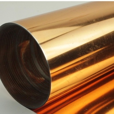 Rolo de folha metálica cobre brilhante enrolada com interior escuro sobre fundo branco