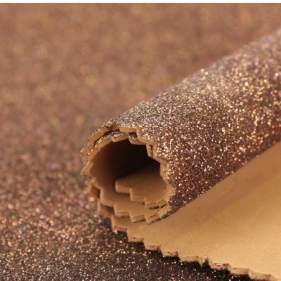 Tecido castanho com glitter dourado e rosa enrolado