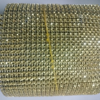 Rolo de malha decorativa dourada com cristais brilhantes