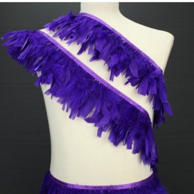 Faixa decorativa roxa de penas numa manequim branca