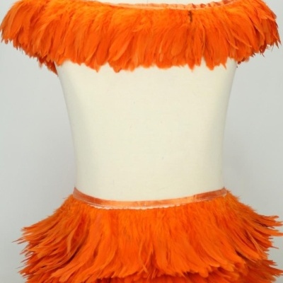 Conjunto de roupa com penas laranja em manequim.