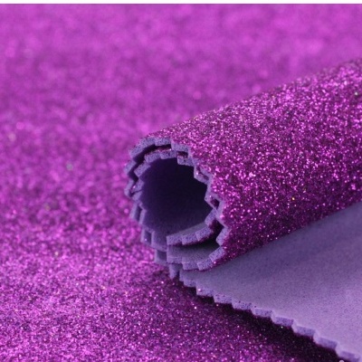 Tecido roxo com glitter enrolado mostrando frente brilhante e verso mate
