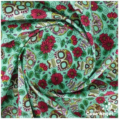 Tecido colorido com estampas de caveiras e flores em fundo verde água