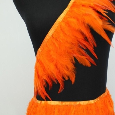 Faixas decorativas de penas laranja num manequim preto