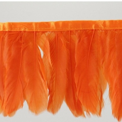 Franja de penas laranja fixadas a uma fita larga da mesma cor