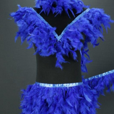 Conjunto de roupa azul com penas e fita de cetim num manequim preto