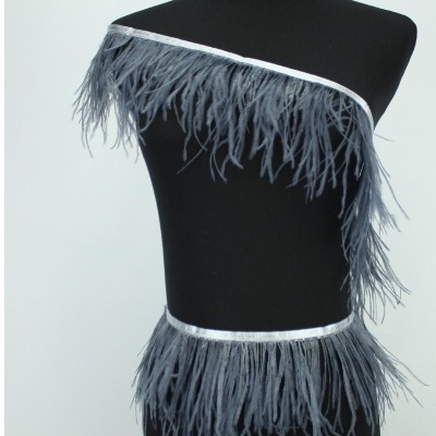 Fitas de tecido prateado com plumas cinzentas no ombro e quadril sobre manequim preto