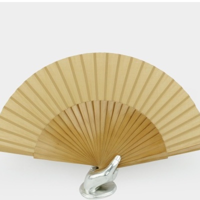 Leque bege em madeira e tecido fita numa mão decorativa prateada