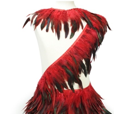 Vestido de penas vermelhas e pretas num manequim branco