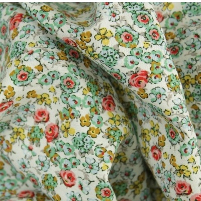 Tecido floral em algodão com padrões vermelhos, amarelos e verdes