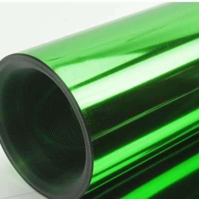 Bobina metálica verde brilhante com interior preto sobre superfície branca