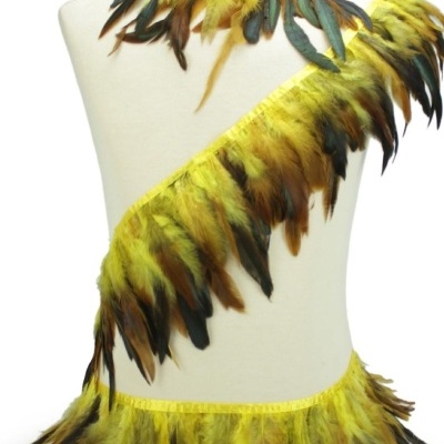 Faixas de penas amarelas com pontas castanhas e verdes em manequim creme