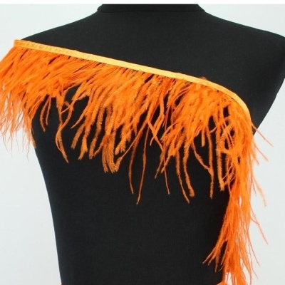 Acessório em plumas cor laranja exposto em manequim negro