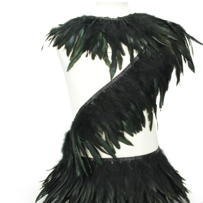 Peça de vestuário com penas pretas num manequim branco
