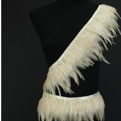 Conjunto de faixa e cinto em penas brancas sobre manequim preto