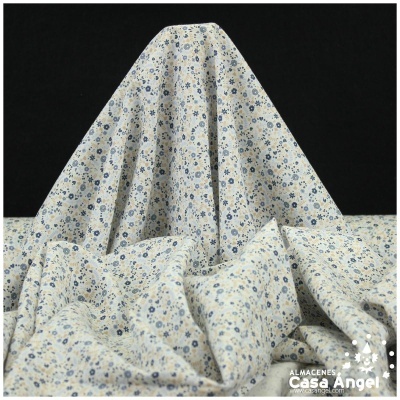 Tecido com padrão floral azul e bege sobre fundo creme