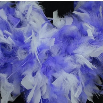 Acessório feito com penas brancas e lilás em fundo escuro