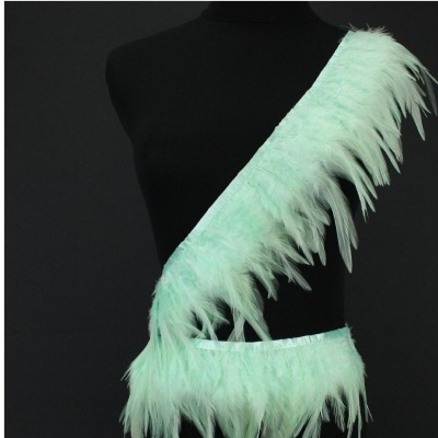 Faixa decorativa de penas verde claro num manequim preto