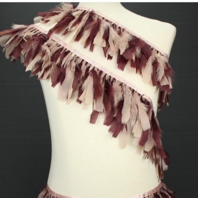 Faixa com penas castanhas e bege em manequim branco