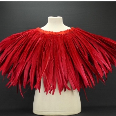 Capa de penas vermelhas em manequim com fundo preto