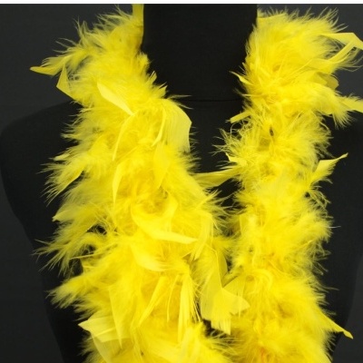 Estola amarela de penas sobre manequim preta em fundo escuro