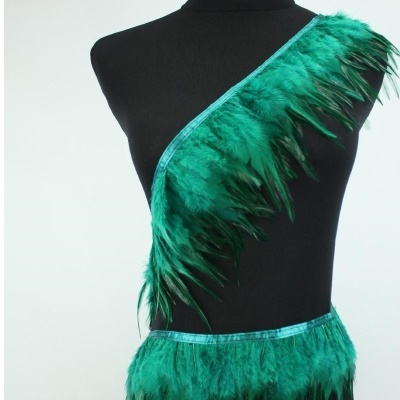 Traje de penas verdes num manequim preto