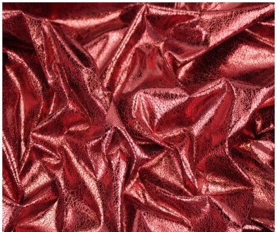 Tecido vermelho metálico brilhante com dobras e textura rugosa