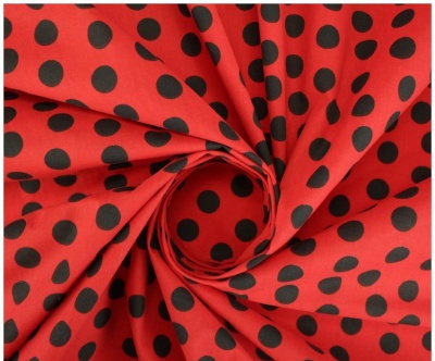 tecido vermelho com bolinhas pretas em padrão espiral