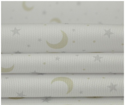 Tecido branco com padrão de luas e estrelas em amarelo e cinzento.