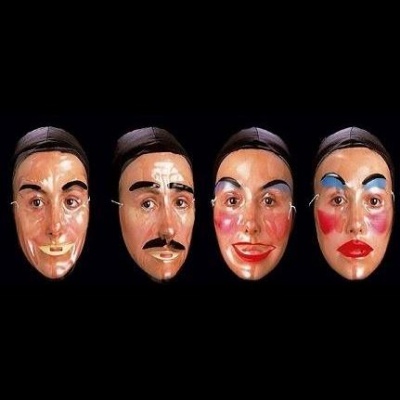 Quatro máscaras faciais decorativas com diferentes expressões e maquilhagem colorida.