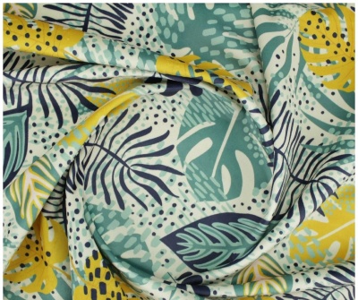 tecido estampado com folhas tropicais amarelas, verdes e azuis