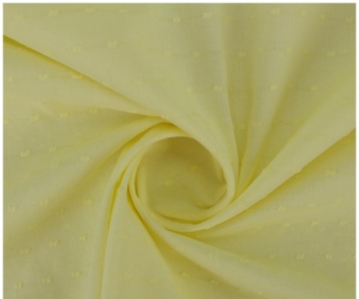 Tecido amarelo claro com textura e padrão de pequenos desenhos enrolado no centro