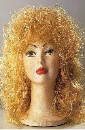 Cabeça de manequim com peruca loira cacheada e rosto pintado.