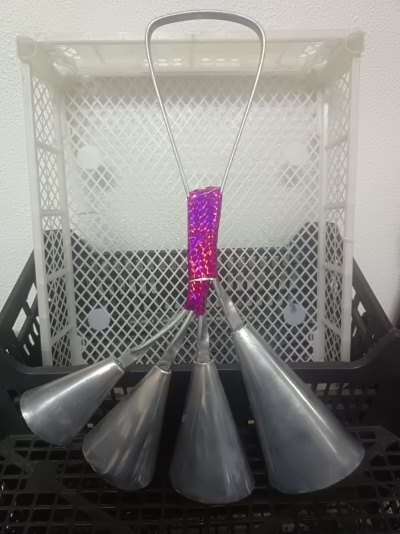 Conjunto de quatro funis metálicos com pega roxa num suporte