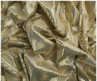 Tecido dourado com padrão de círculos perfurados